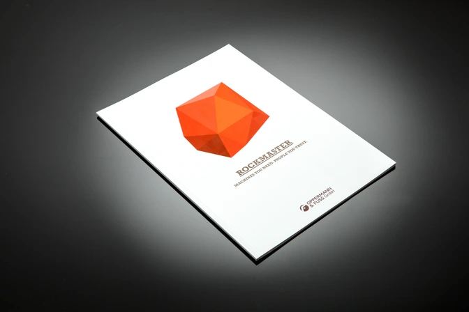 Print: ROCKMASTER-Broschüre mit orangefarbenem Polygon-Logo auf weißem Cover